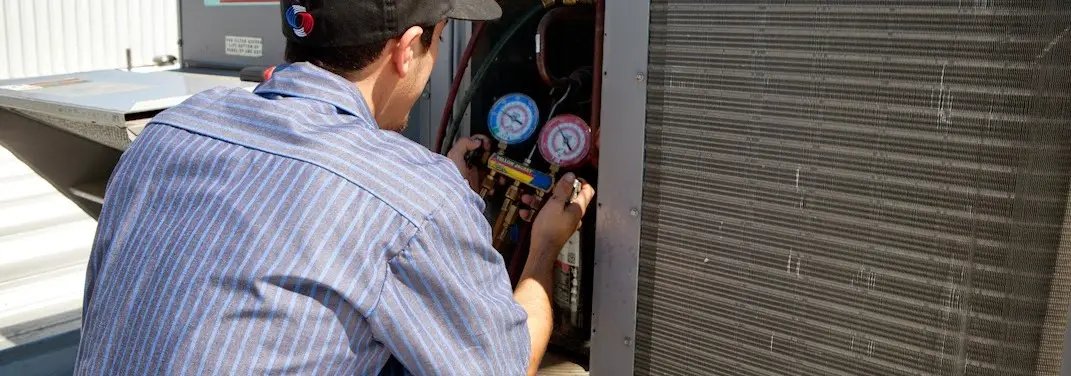 HVAC technician servicing a condenser unit in Calcutta